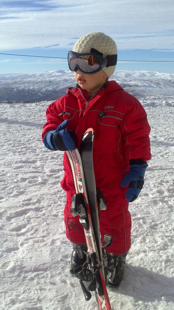 Child in ski gear on mountain top at the Snow Farm.